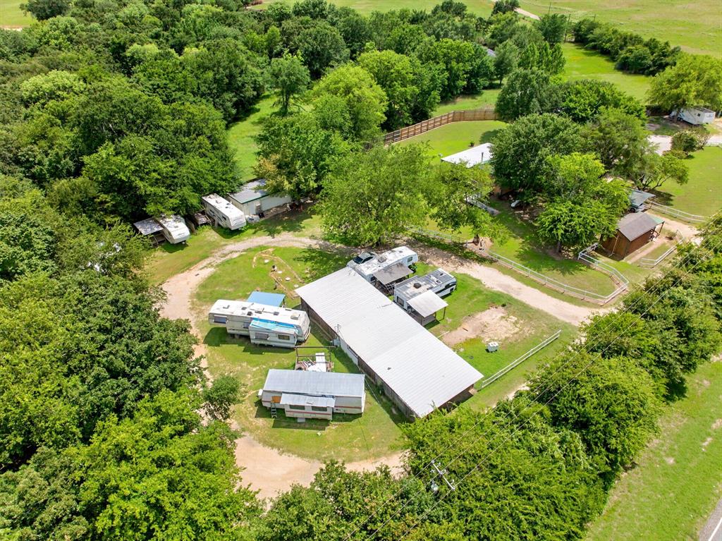 111 County Road 2806 Mabank, TX 75147 - Photo 33 of 34 Expansive property featuring mature trees, a metal-roofed structure, unpaved roadways, and surrounding green landscapes