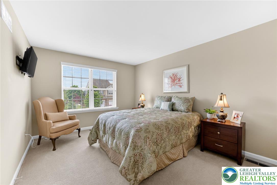 5440 Spring Ridge Drive West Macungie, PA 18062 - Photo 25 of 40 A well-lit bedroom features plush carpeting and a wide window offering neighborhood views.