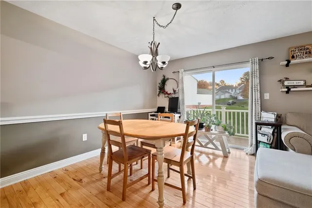 a dining room with furniture a chandelier and wooden floor