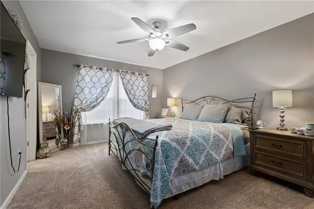 a bedroom with a bed and ceiling fan