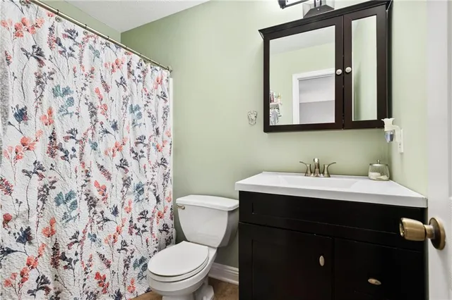 a bathroom with a toilet a sink and a mirror