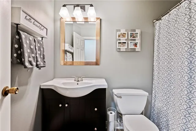 a bathroom with a sink and mirror with toilet