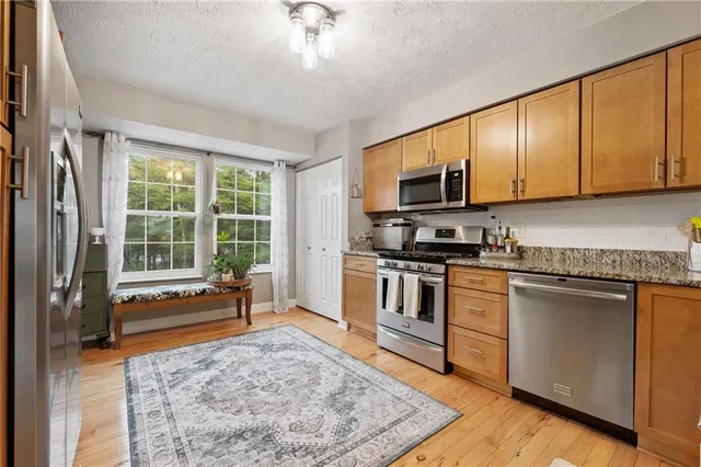 a kitchen with granite countertop a stove a sink and a microwave