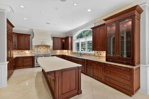a kitchen with kitchen island granite countertop a sink window and cabinets