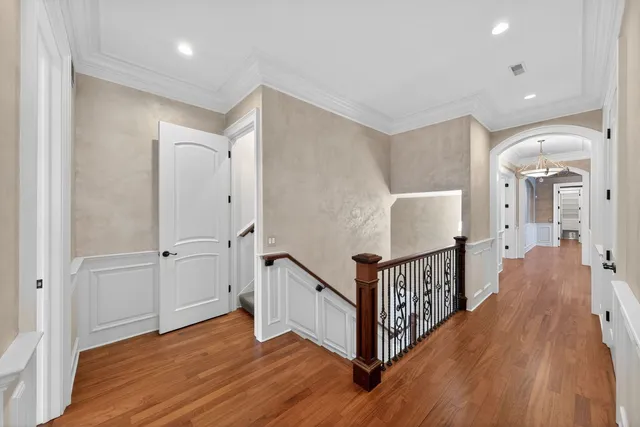 a view of a hallway with wooden floor and staircase