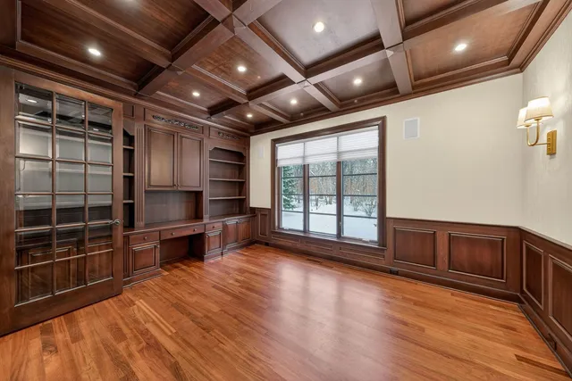 a view of empty room with wooden floor and windows