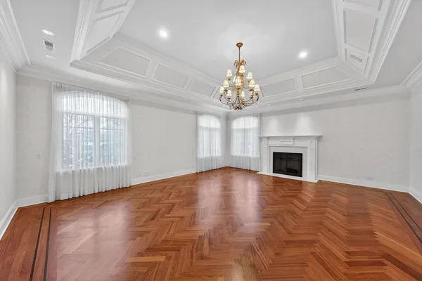 a view of empty room with fireplace and chandelier