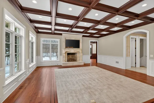 a view of empty room with wooden floor and fireplace