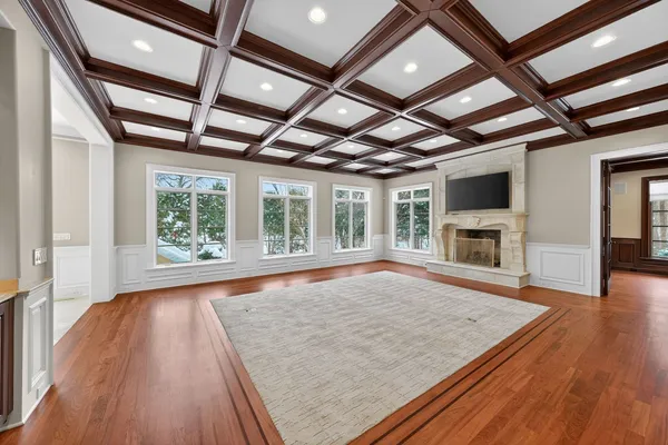 wooden floor in an empty room with wooden floor and a fireplace