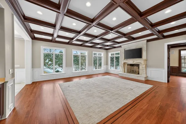 wooden floor in an empty room with wooden floor and a fireplace
