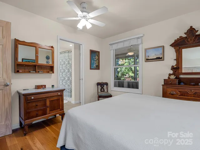 a bedroom with a bed and a flat tv screen on the dresser