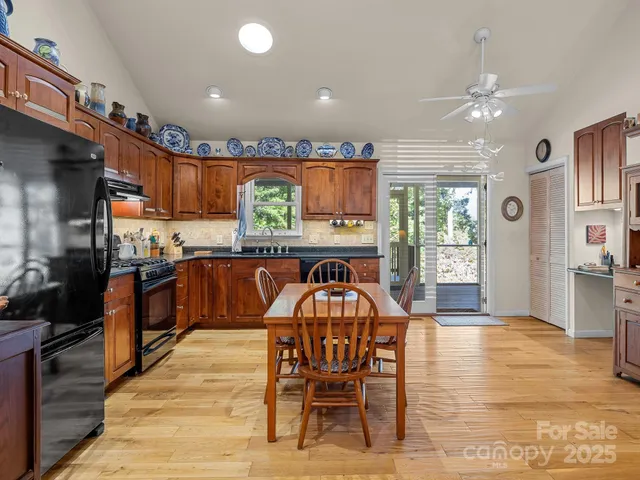 a kitchen with stainless steel appliances granite countertop a table chairs and a refrigerator