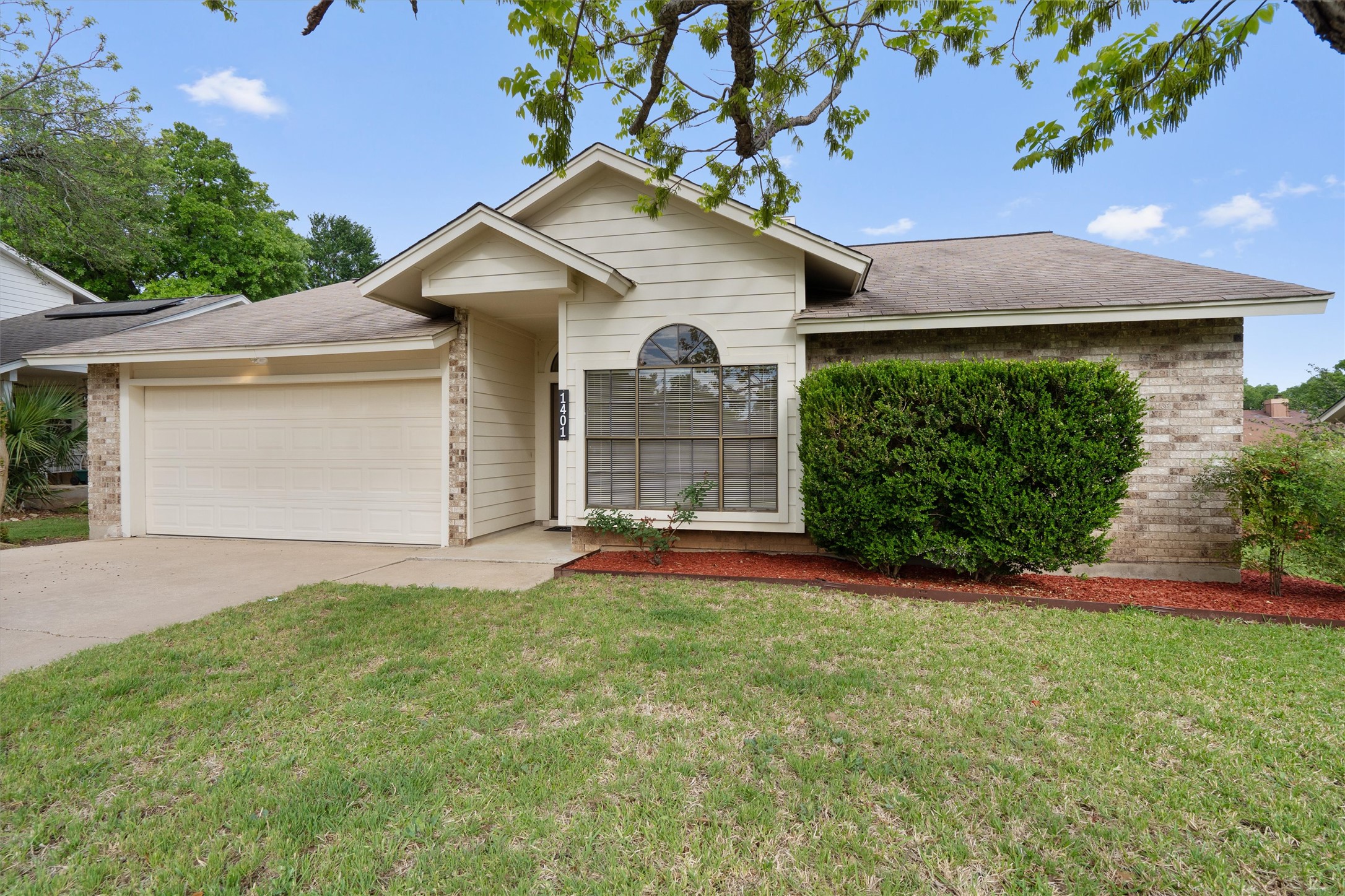 1401 Plum Creek Road Cedar Park, TX 78613 - Photo 4 of 30 Ranch-style house with brick siding, a front yard, an attached garage, and concrete driveway