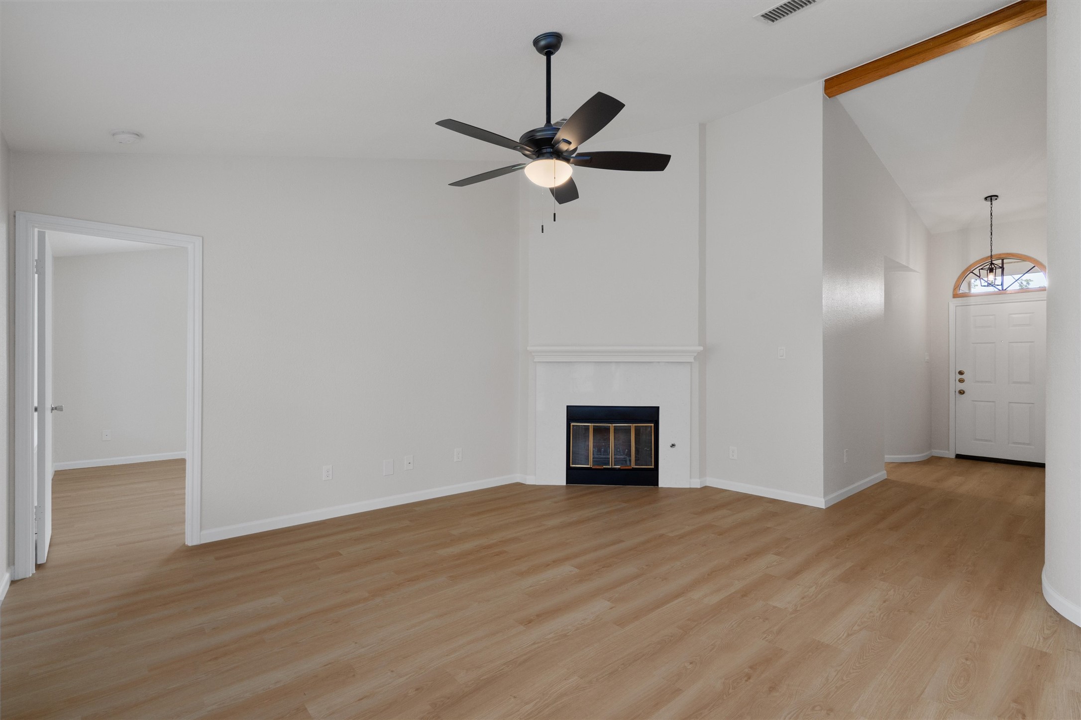 1401 Plum Creek Road Cedar Park, TX 78613 - Photo 6 of 30 Unfurnished living room featuring vaulted ceiling, light wood-type flooring, a ceiling fan, and a fireplace