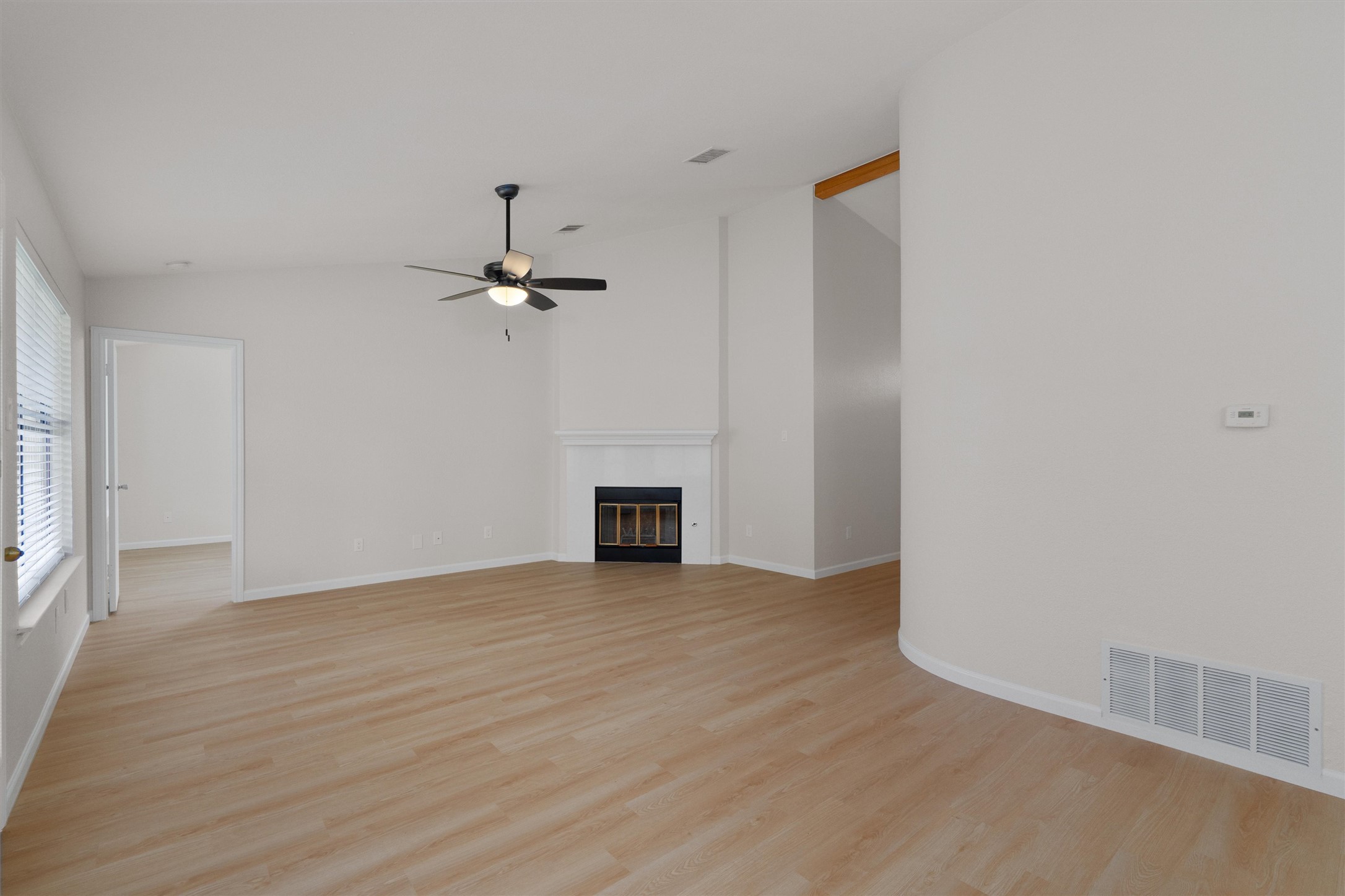 1401 Plum Creek Road Cedar Park, TX 78613 - Photo 9 of 30 Unfurnished living room with lofted ceiling, light wood finished floors, a ceiling fan, and a glass covered fireplace