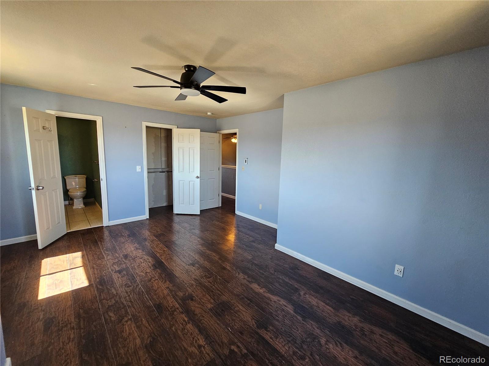 16985 Sage Crest Road Peyton, CO 80831 - Photo 17 of 25 an empty room with wooden floor and windows
