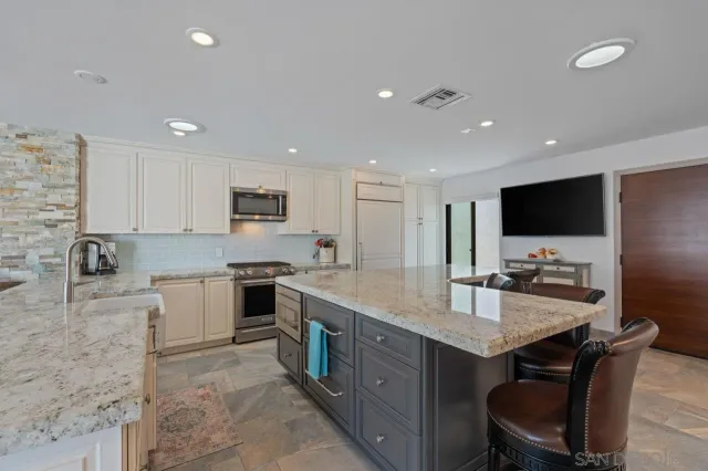 a kitchen with center island table and chairs