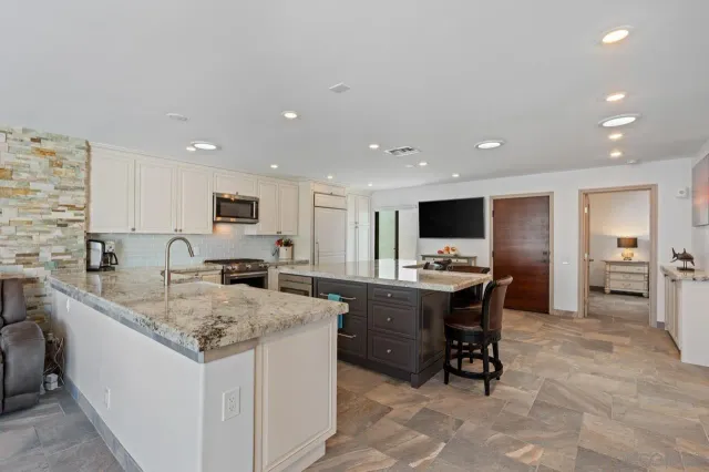 a kitchen with a granite countertop sink and cabinets