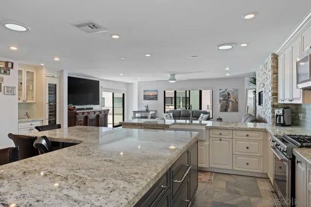 a kitchen with granite countertop kitchen island a sink appliances and a counter top space