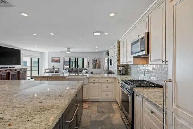 a kitchen with granite countertop a sink stove and cabinets
