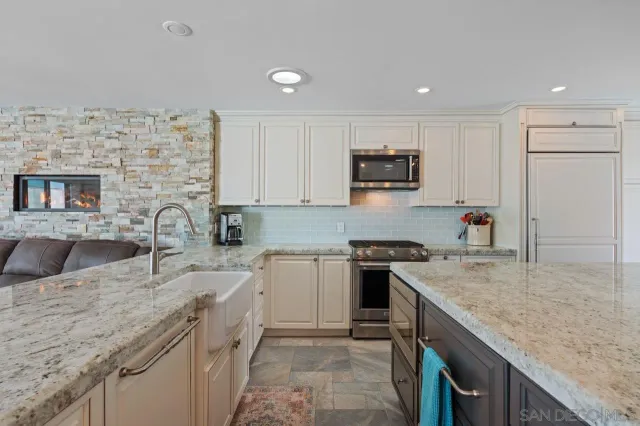 a kitchen with stainless steel appliances granite countertop a sink stove and microwave