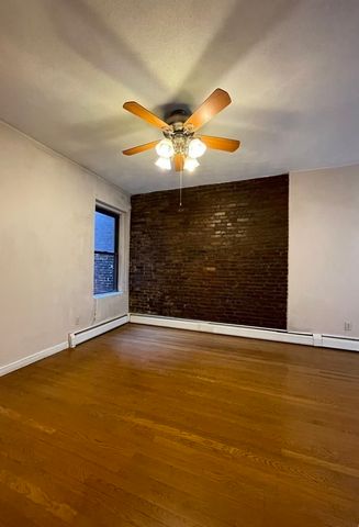 a view of an empty room with window and a ceiling fan