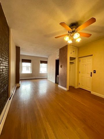 a view of empty room with window and wooden floor