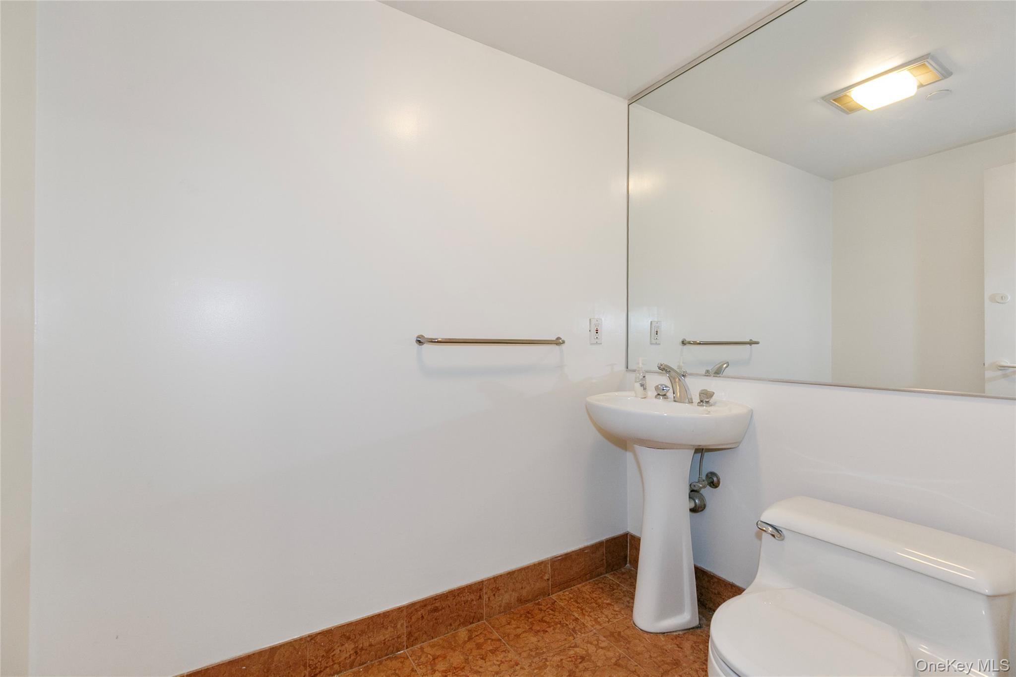 100 Cutter Mill Road, Unit 2C Great Neck, NY 11021 - Photo 12 of 29 a bathroom with a sink toilet and a mirror