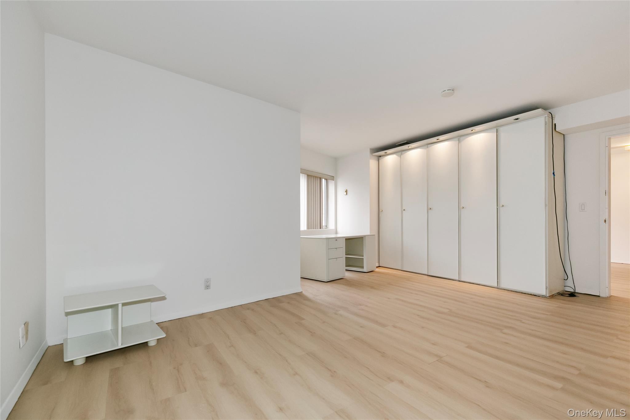 100 Cutter Mill Road, Unit 2C Great Neck, NY 11021 - Photo 19 of 29 a view of an empty room with wooden floor and a window