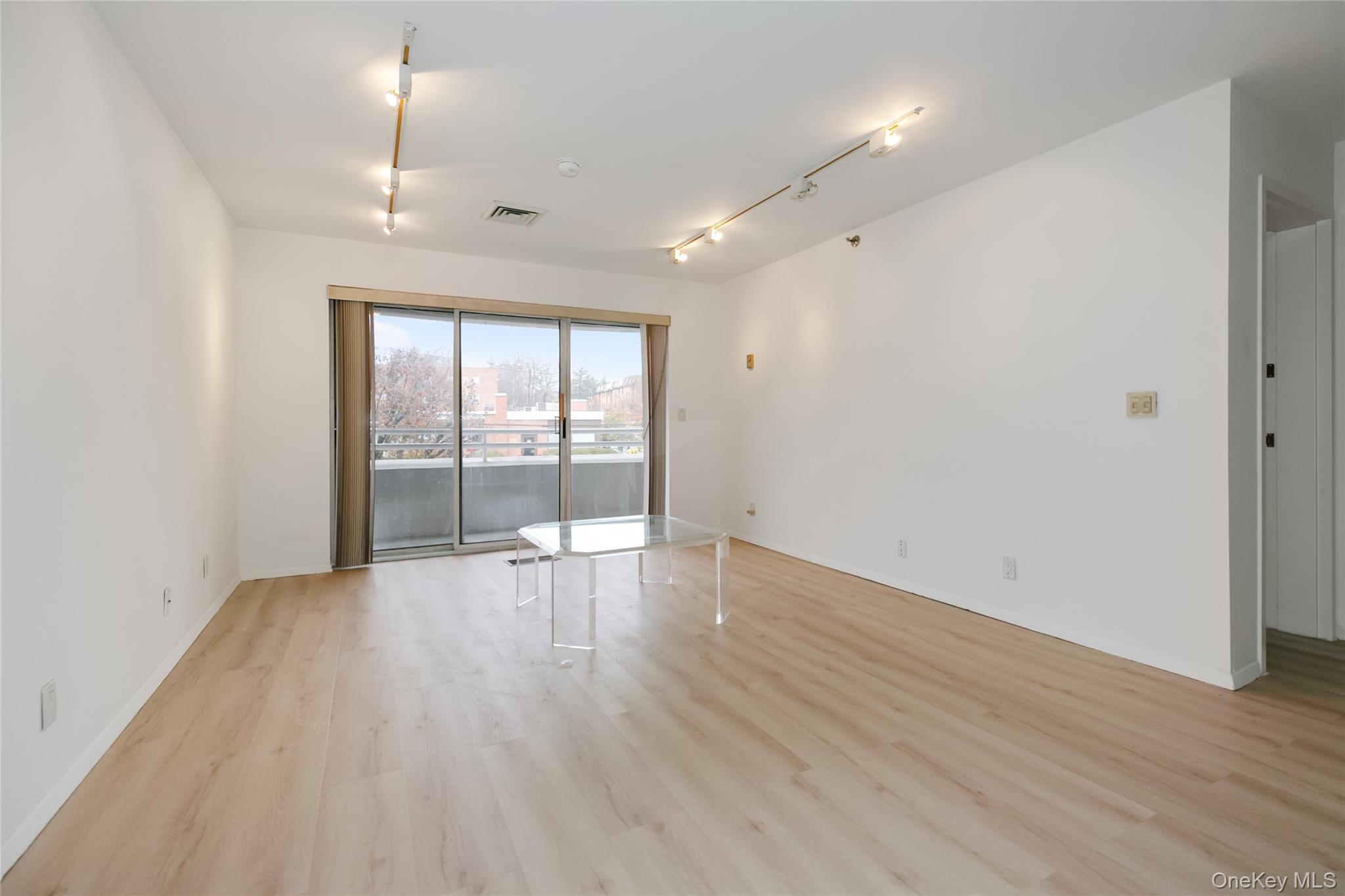 100 Cutter Mill Road, Unit 2C Great Neck, NY 11021 - Photo 25 of 29 an empty room with wooden floor and windows