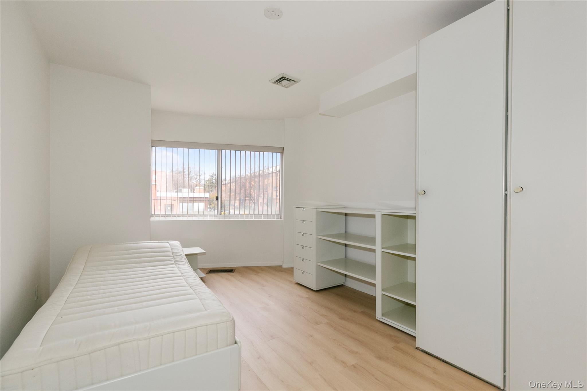 100 Cutter Mill Road, Unit 2C Great Neck, NY 11021 - Photo 26 of 29 a bedroom with a bed and a window