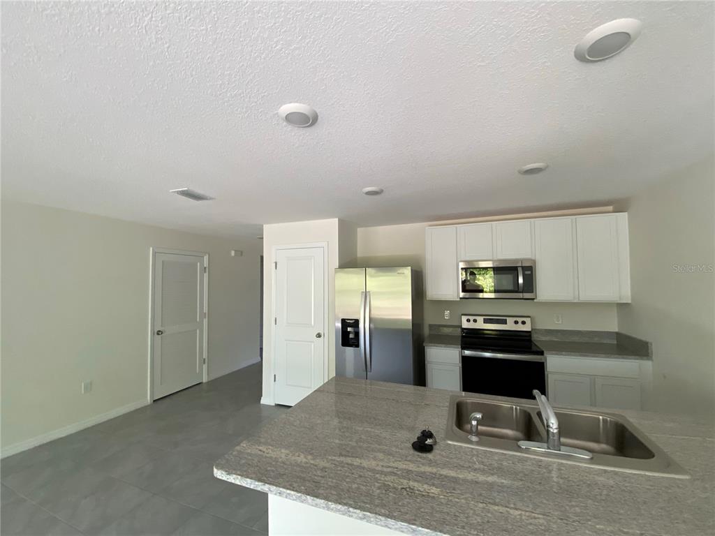 492 Hickory Course Loop Ocala, FL 34472 - Photo 7 of 28 a kitchen with kitchen island a counter top space cabinets stainless steel appliances and a counter top space
