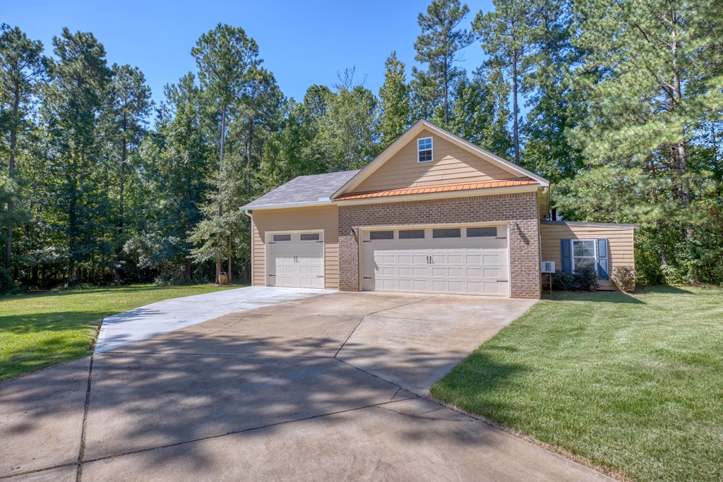 182 Oak Ridge Drive Waverly Hall, GA 31831 - Photo 13 of 40 a front view of a house with a yard and garage