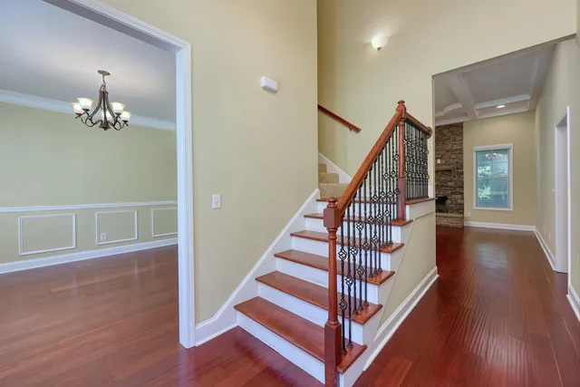 a view of a hallway with wooden floor and staircase