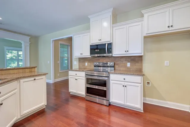 a kitchen with granite countertop white cabinets and appliances