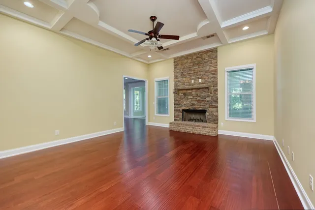a view of a livingroom with wooden floor a ceiling fan and a window