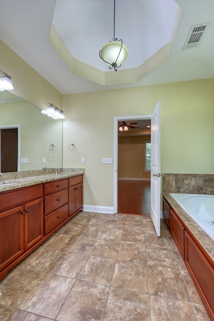 182 Oak Ridge Drive Waverly Hall, GA 31831 - Photo 33 of 40 a spacious bathroom with a granite countertop sink and a bathtub