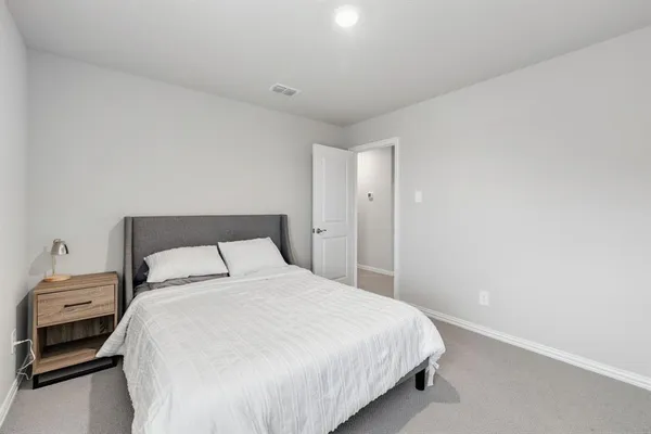 a bedroom with a bed and a lamp