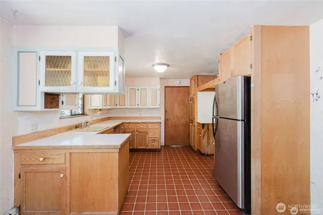 a kitchen with a sink a refrigerator and cabinets