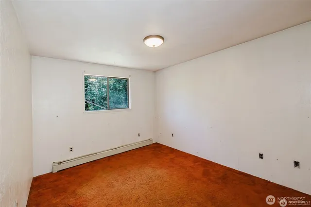 an empty room with a ceiling fan and window