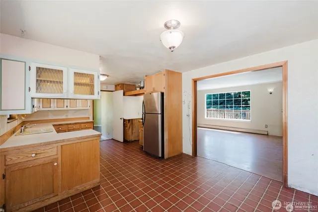 a kitchen that has a lot of cabinets and wooden floor