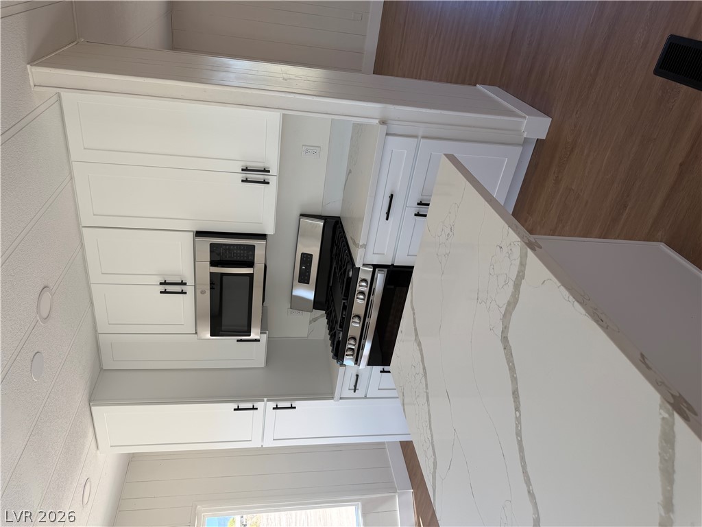 6401 Hafen Ranch Road Pahrump, NV 89061 - Photo 9 of 22 Gleaming stone countertops and crisp white cabinetry define this beautifully updated modern kitchen space.