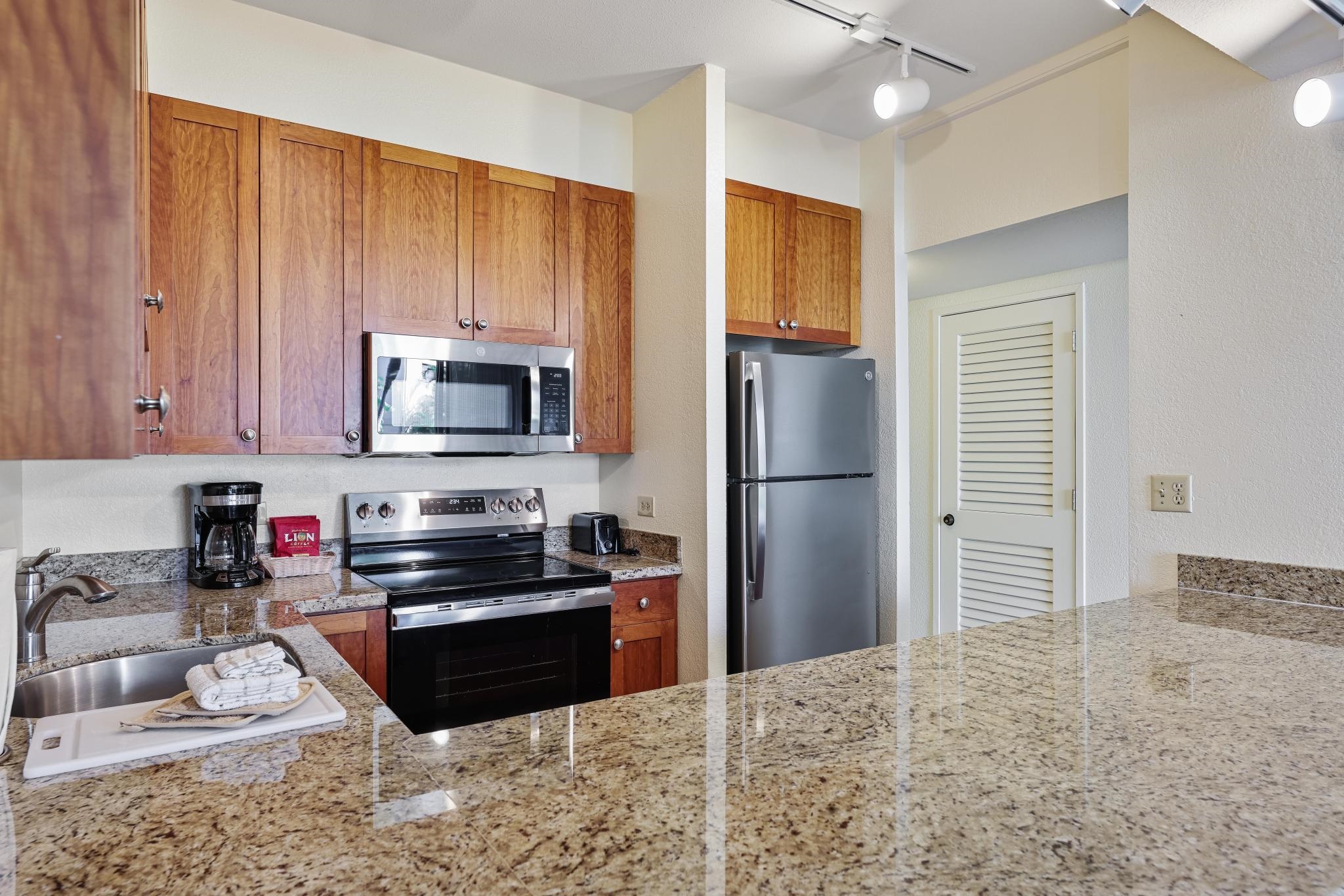 3445 Lower Honoapiilani Road, Unit 151 Lahaina, HI 96761 - Photo 11 of 42 a kitchen with stainless steel appliances granite countertop a refrigerator stove top oven and sink