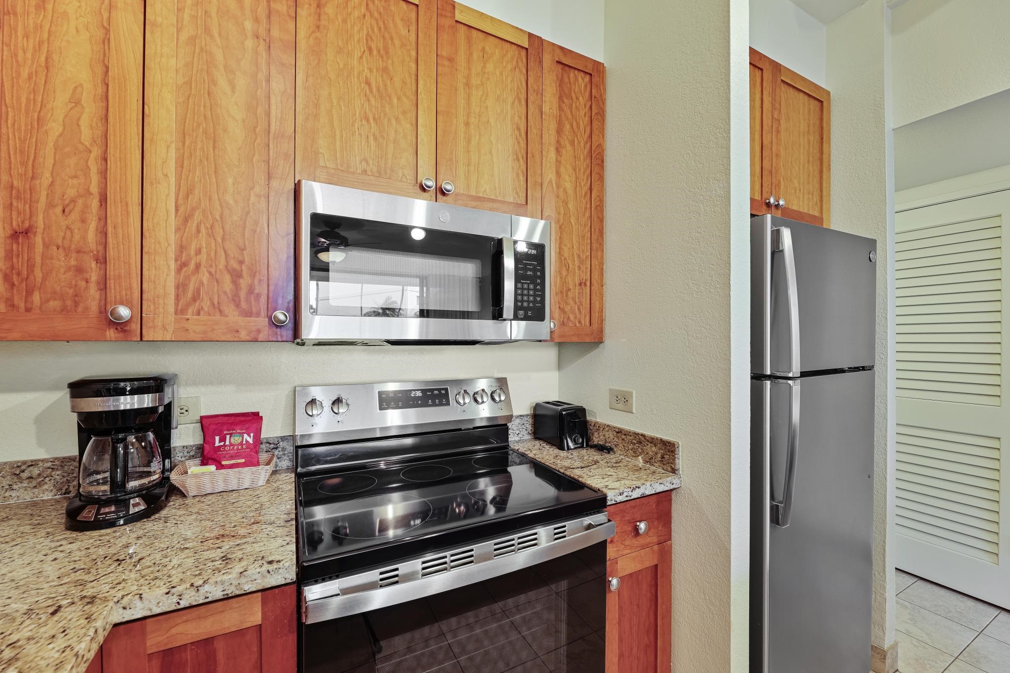 3445 Lower Honoapiilani Road, Unit 151 Lahaina, HI 96761 - Photo 13 of 42 a kitchen with granite countertop a stove and a microwave