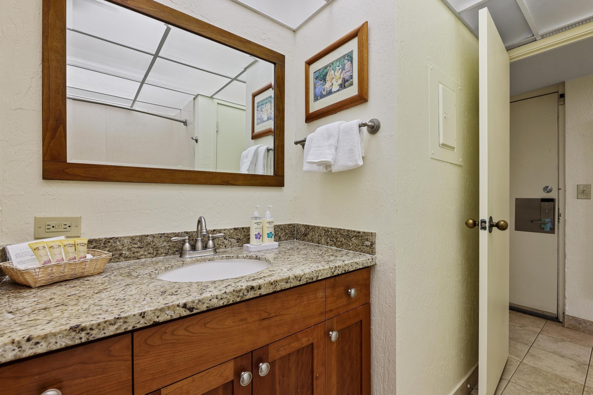 3445 Lower Honoapiilani Road, Unit 151 Lahaina, HI 96761 - Photo 17 of 42 a bathroom with a granite countertop sink a mirror and vanity