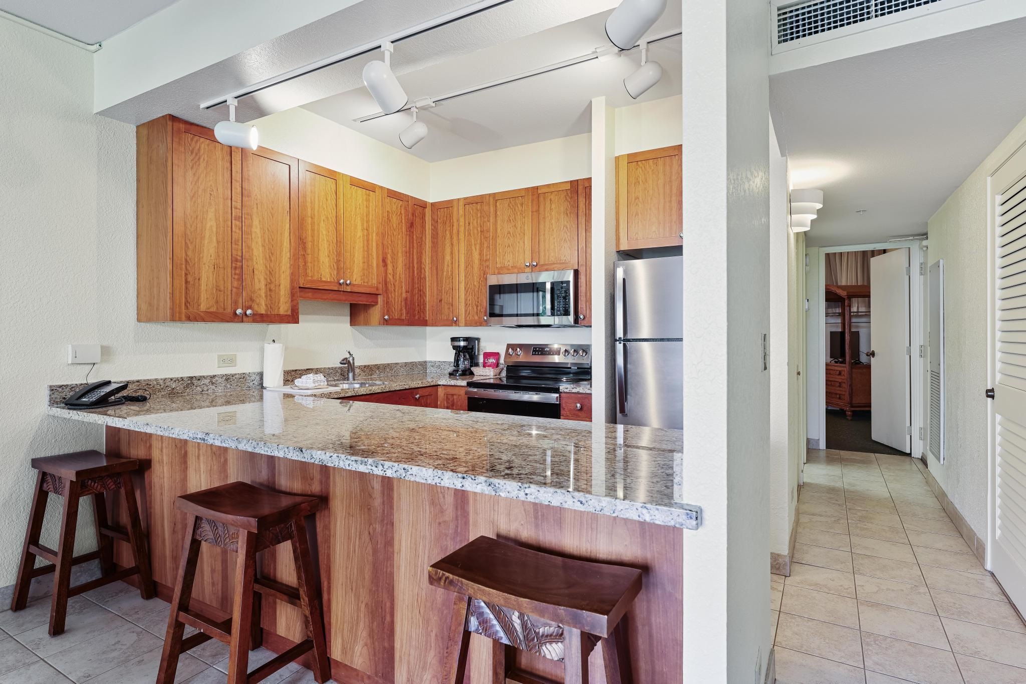 3445 Lower Honoapiilani Road, Unit 151 Lahaina, HI 96761 - Photo 10 of 42 a kitchen with stainless steel appliances granite countertop a refrigerator and a stove top oven