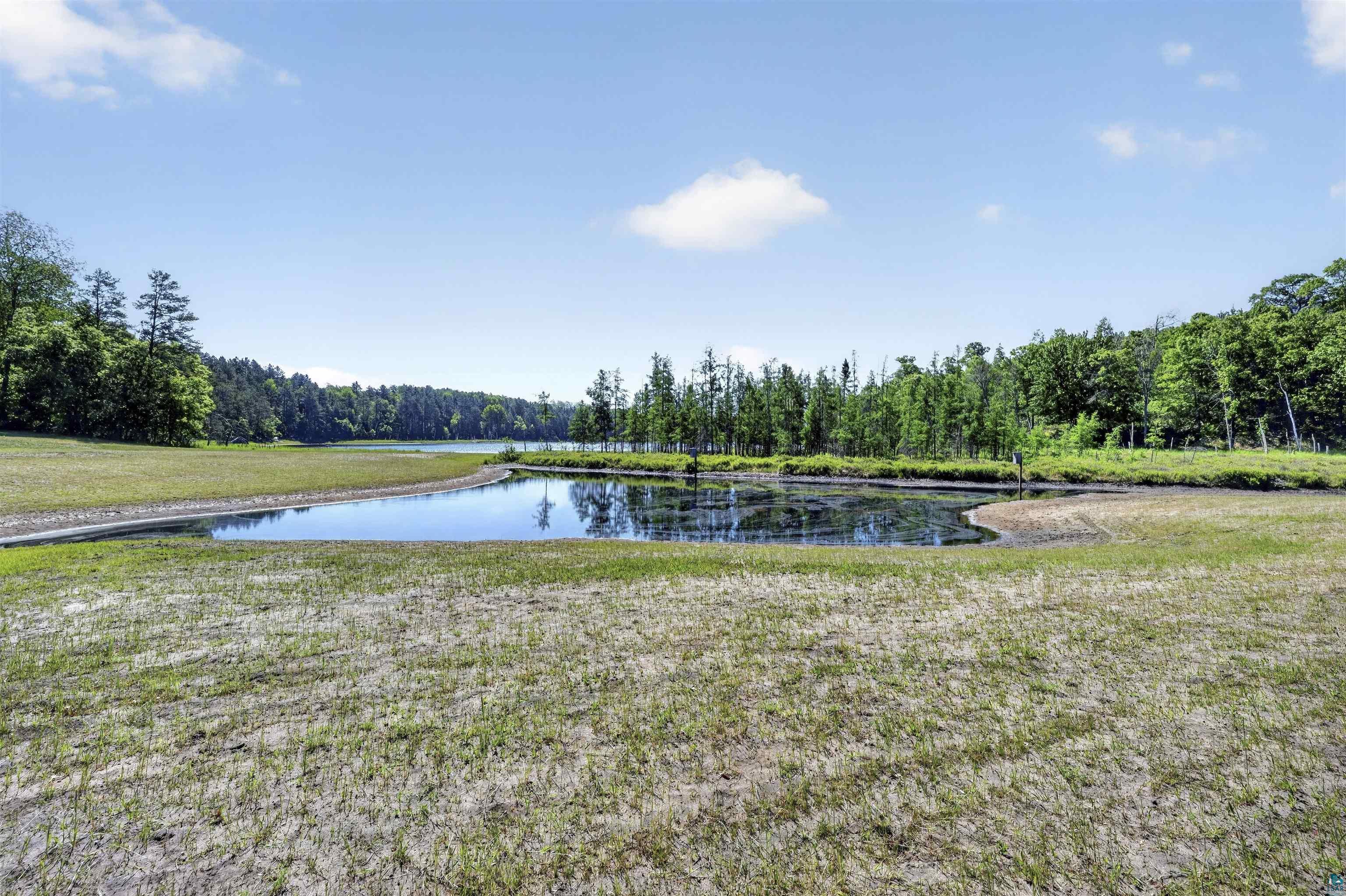 11702 East Mail Road Gordon, WI 54838 - Photo 20 of 60 Expansive grassy area bordering a tranquil pond and surrounding woodlands