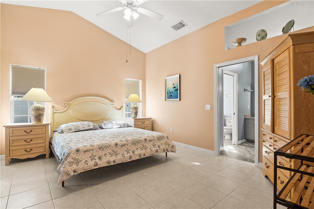 922 Jackson Way Fort Pierce, FL 34949 - Photo 19 of 34 a bedroom with a bed and a chandelier