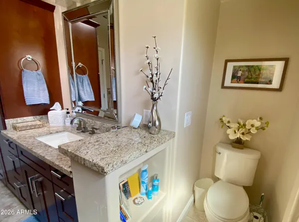 a bathroom with a granite countertop sink and a mirror