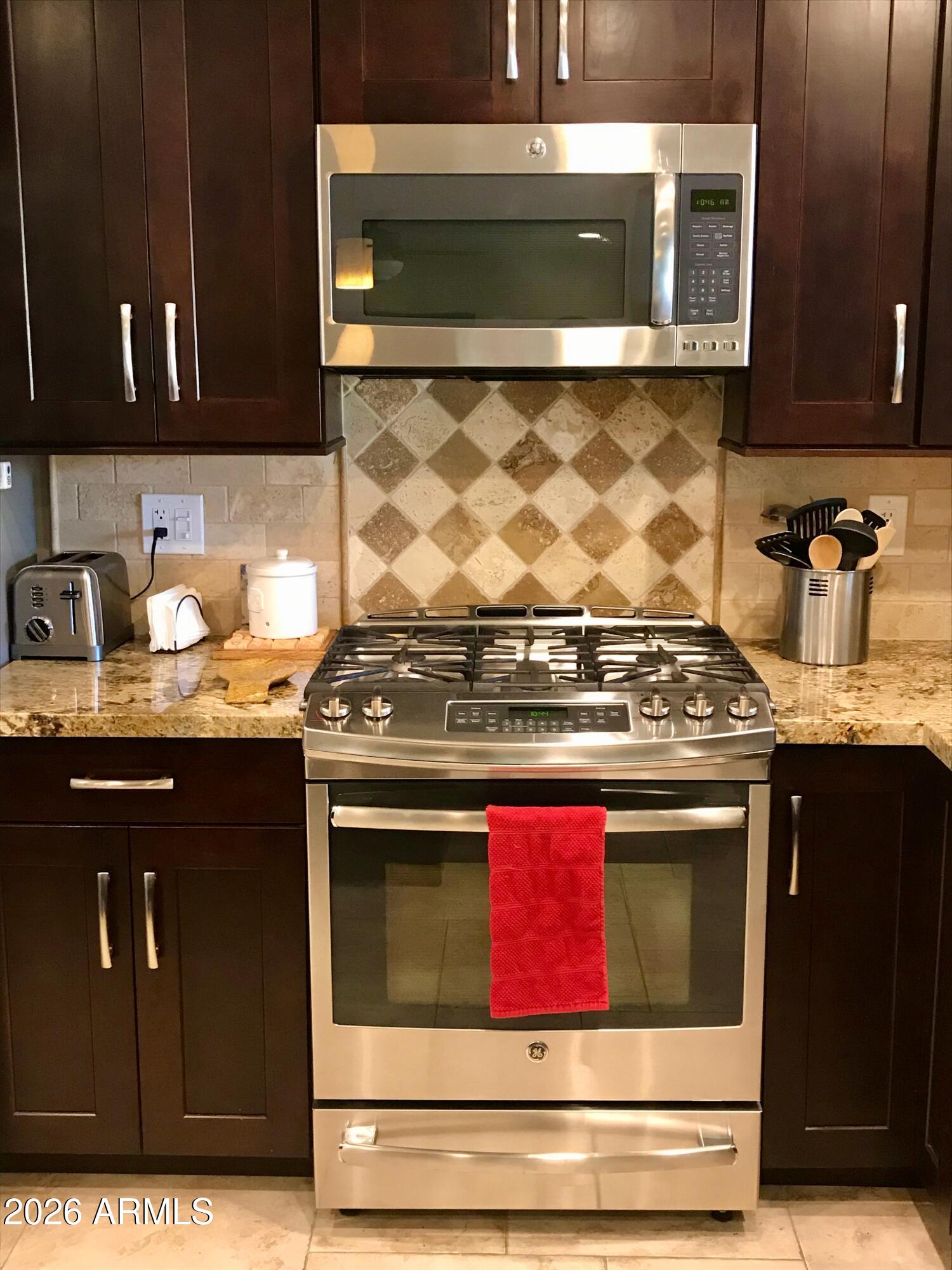 5610 East Justine Road Scottsdale, AZ 85254 - Photo 4 of 28 a kitchen with stainless steel appliances granite countertop a stove and a microwave